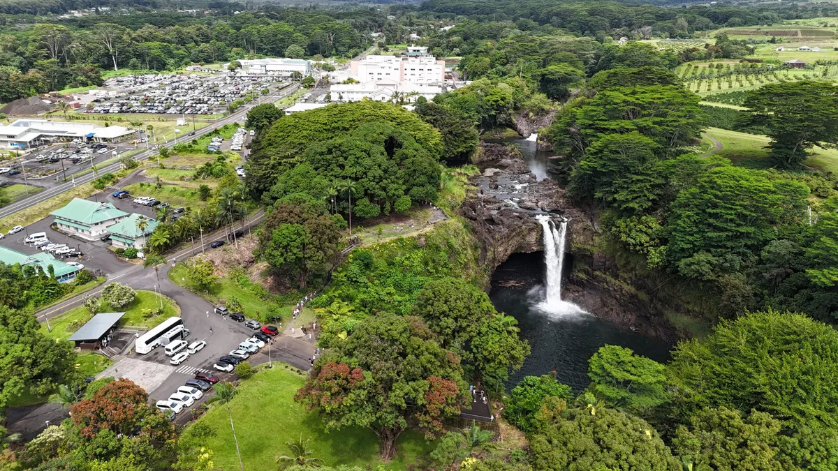 Aerial view of a lush green waterfall valley on the hilo hawaii waterfalls trail near the Hamakua Coast